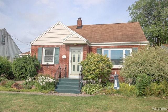 112 Vegola Ave, Cheektowaga, NY 14225 - view of front of property featuring brick siding, a chimney, roof with shingles, and a front lawn