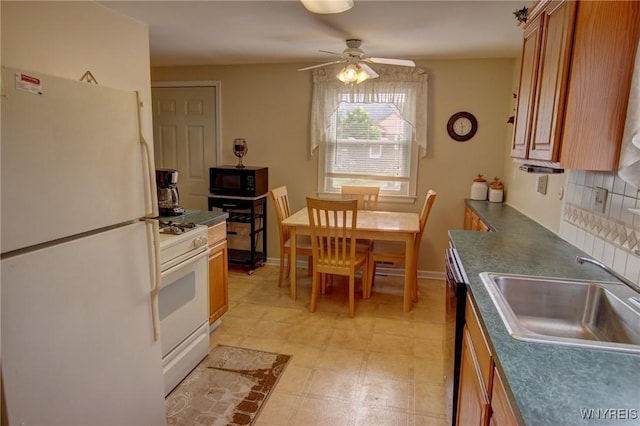 112 Vegola Ave, Cheektowaga, NY 14225 - kitchen with white appliances, brown cabinetry, ceiling fan, dark countertops, and tasteful backsplash