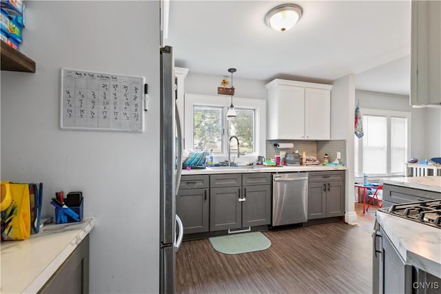 423 Highland Ave, Dewitt, NY 13057 - kitchen featuring dishwasher, dark wood finished floors, light countertops, tasteful backsplash, and hanging light fixtures