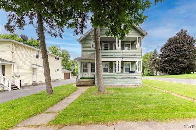 423 Highland Ave, Dewitt, NY 13057 - view of front of home with a front lawn, covered porch, an outbuilding, and a balcony