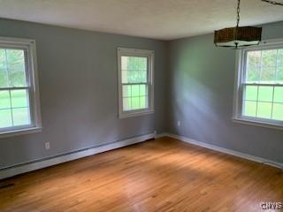 884 Kibby Rd, Lysander, NY 13027 - spare room with a baseboard heating unit, healthy amount of natural light, and light wood-type flooring