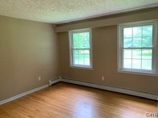 884 Kibby Rd, Lysander, NY 13027 - spare room featuring a baseboard heating unit, light wood-style floors, and a textured ceiling