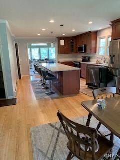 884 Kibby Rd, Lysander, NY 13027 - kitchen featuring stainless steel microwave, light wood finished floors, crown molding, black / electric stove, and recessed lighting