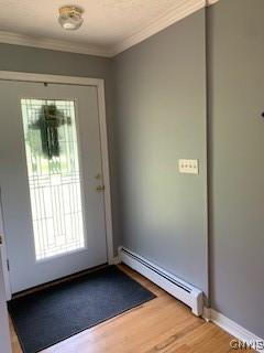 884 Kibby Rd, Lysander, NY 13027 - entryway with a baseboard radiator, wood finished floors, and crown molding