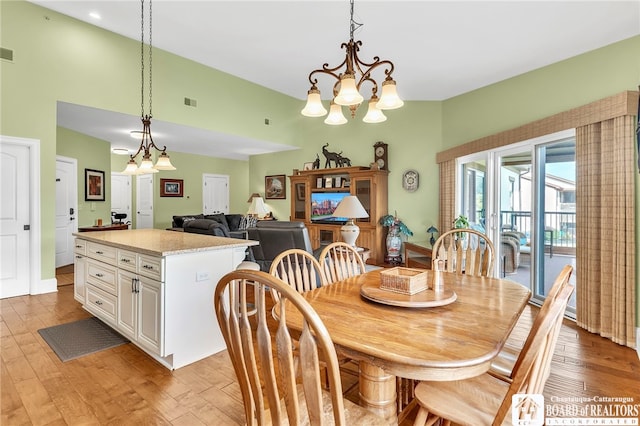 743 Legacy Dr Unit 209, Lewiston, NY 14092 - dining space featuring light wood-type flooring, a chandelier, and a towering ceiling