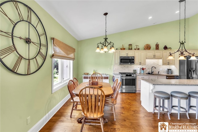 743 Legacy Dr Unit 209, Lewiston, NY 14092 - dining room featuring vaulted ceiling, wood finished floors, a chandelier, and recessed lighting