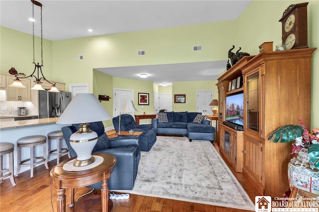 743 Legacy Dr Unit 209, Lewiston, NY 14092 - living room with light wood-type flooring, a towering ceiling, and recessed lighting