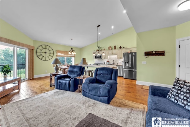 743 Legacy Dr Unit 209, Lewiston, NY 14092 - living room with light wood finished floors, a chandelier, and high vaulted ceiling