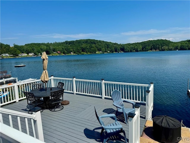 3018 Camp Rd, Eaton, NY 13334 - dock featuring a deck with water view, outdoor dining area, and a forest view