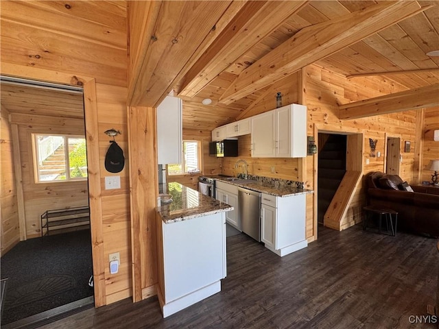 3018 Camp Rd, Eaton, NY 13334 - kitchen featuring stainless steel dishwasher, wood walls, white cabinets, open floor plan, and dark wood-style floors