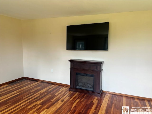 70 Williams Ave, Wellsville, NY 14895 - unfurnished living room featuring hardwood / wood-style floors and a glass covered fireplace