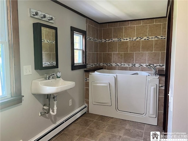 70 Williams Ave, Wellsville, NY 14895 - full bath featuring a baseboard heating unit, a garden tub, tile patterned floors, and washer and clothes dryer