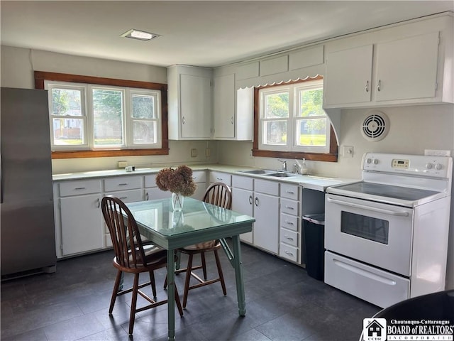 70 Williams Ave, Wellsville, NY 14895 - kitchen with white electric range oven, freestanding refrigerator, plenty of natural light, and light countertops