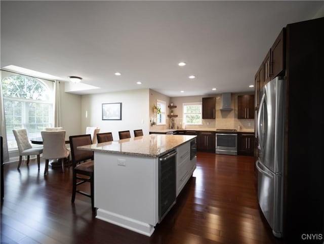 2480 Middle Rd, Oneida, NY 13421 - kitchen featuring wall chimney exhaust hood, freestanding refrigerator, a breakfast bar area, dark wood-style floors, and recessed lighting