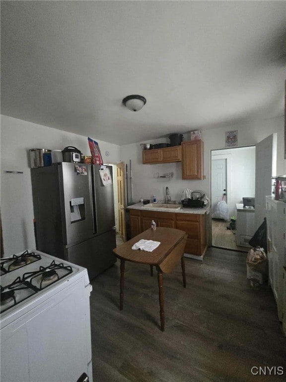 225 Lakeview Ave, Syracuse, NY 13204 - kitchen with white gas range oven, stainless steel fridge, dark wood-style floors, light countertops, and brown cabinetry