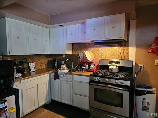 1125 Adams St, Utica, NY 13501 - kitchen featuring stainless steel range with gas stovetop, under cabinet range hood, white cabinetry, backsplash, and wood finished floors