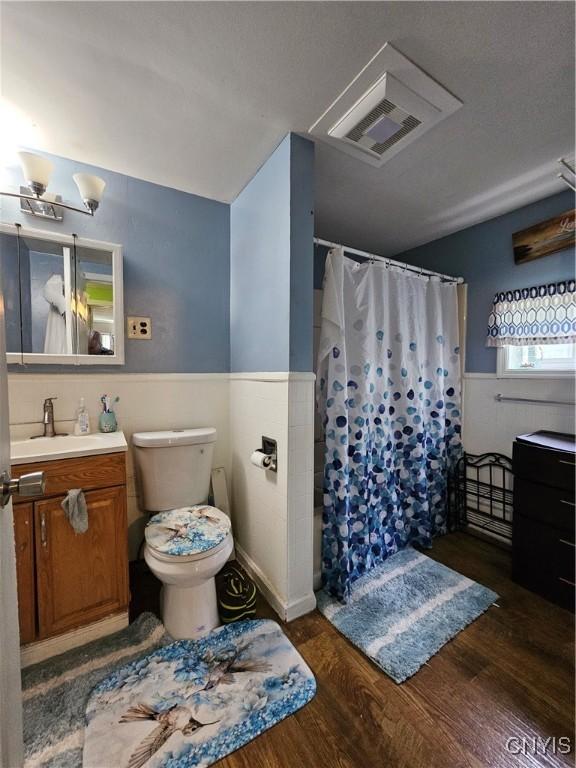 1125 Adams St, Utica, NY 13501 - full bath with vanity, a wainscoted wall, wood finished floors, and a shower with curtain