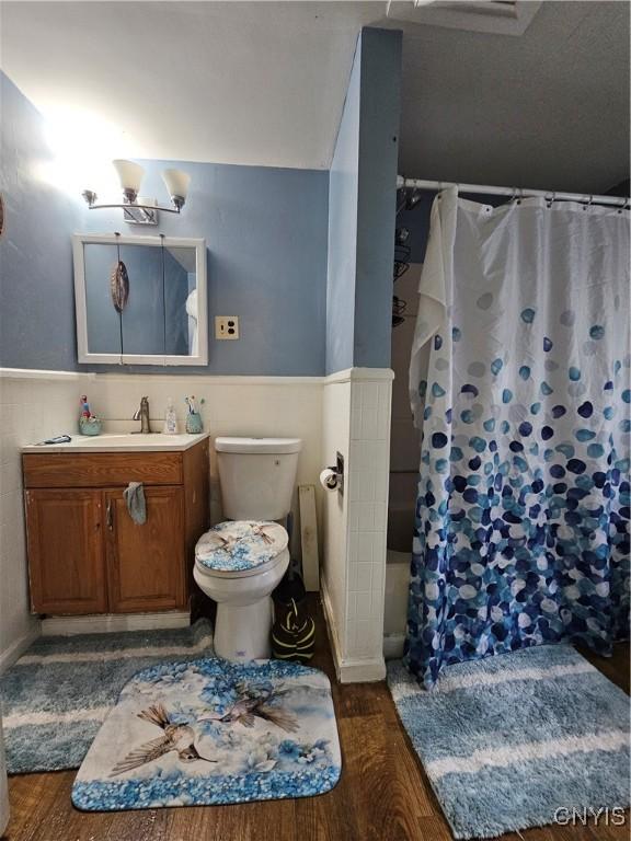 1125 Adams St, Utica, NY 13501 - bathroom featuring vanity, wainscoting, wood finished floors, and a shower with curtain