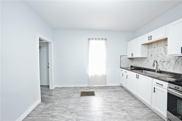 290 Riverside Ave, Buffalo, NY 14207 - kitchen with backsplash, gas stove, white cabinets, and dark stone counters