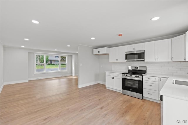 105 Benoit Dr, Geddes, NY 13209 - kitchen featuring stainless steel appliances, tasteful backsplash, light wood-style floors, white cabinets, and recessed lighting
