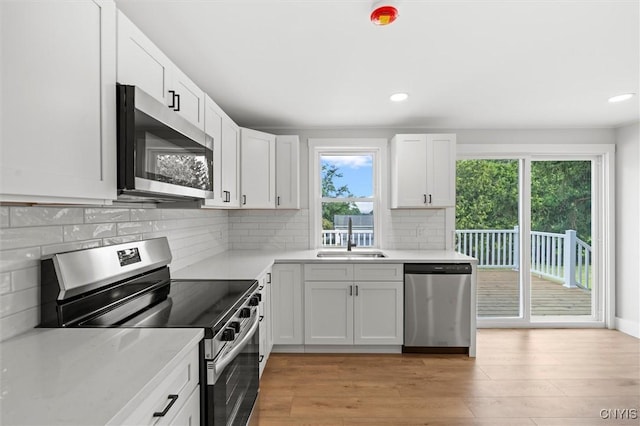105 Benoit Dr, Geddes, NY 13209 - kitchen with stainless steel appliances, light countertops, white cabinetry, light wood-style floors, and recessed lighting