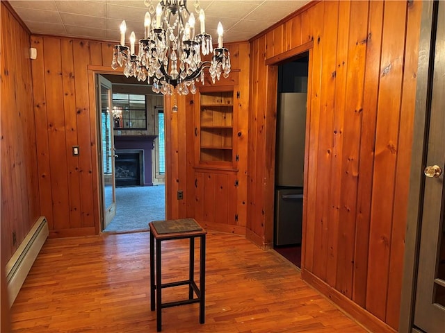 20-22 N Belmont Cir, Oneonta, NY 13820 - corridor featuring baseboard heating, wood walls, a chandelier, and wood finished floors