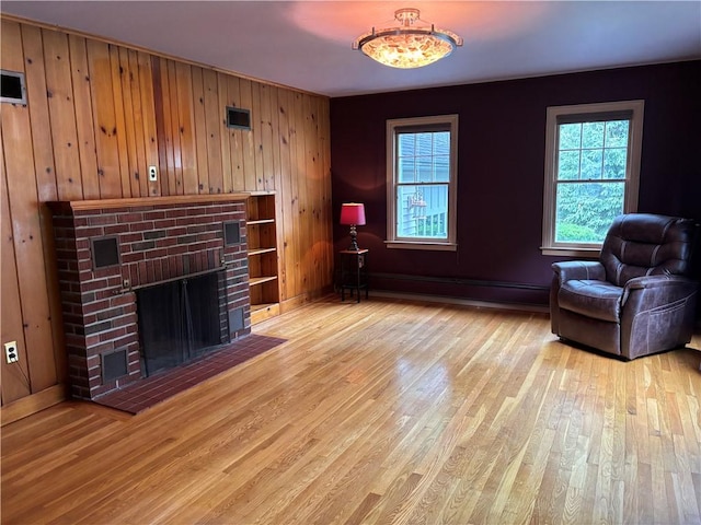 20-22 N Belmont Cir, Oneonta, NY 13820 - living room featuring a baseboard radiator, light wood finished floors, wood walls, and a fireplace
