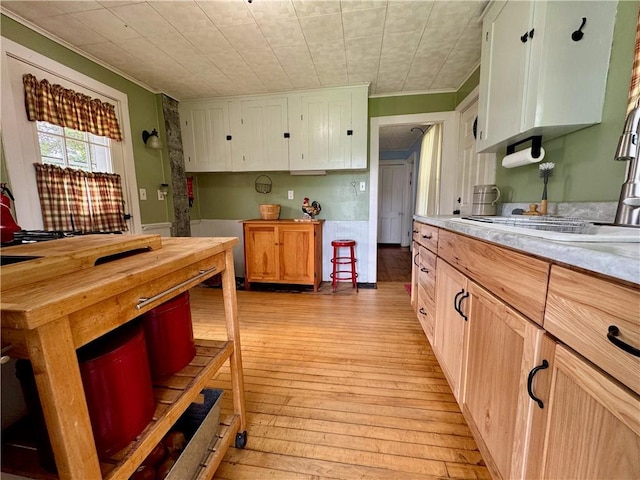 44 Bloom St, Butternuts, NY 13776 - kitchen featuring crown molding, light wood finished floors, light countertops, and white cabinets