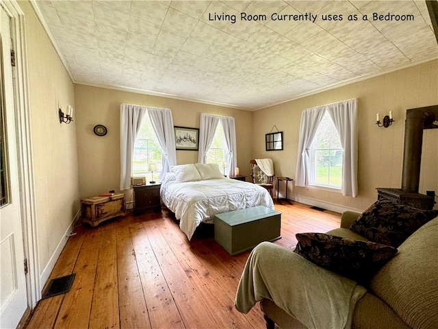 44 Bloom St, Butternuts, NY 13776 - bedroom with hardwood / wood-style flooring, crown molding, and a wood stove