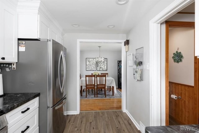 451 Moore Ave, Tonawanda, NY 14223 - kitchen with wood finished floors, white cabinets, freestanding refrigerator, dark stone countertops, and recessed lighting