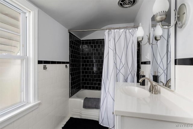 451 Moore Ave, Tonawanda, NY 14223 - bathroom with tile walls, shower / tub combo with curtain, vanity, and lofted ceiling
