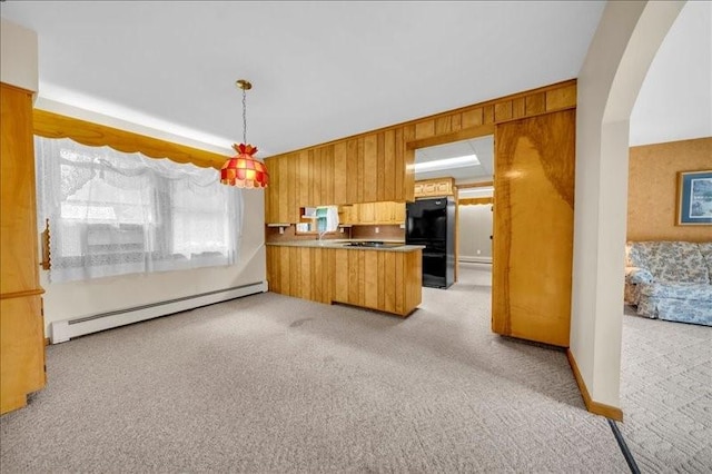 12 Sunset Dr, Afton, NY 13730 - kitchen with a baseboard heating unit, freestanding refrigerator, light carpet, a peninsula, and wood walls
