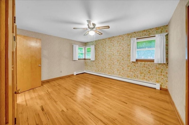12 Sunset Dr, Afton, NY 13730 - spare room featuring a baseboard heating unit, wood finished floors, ceiling fan, and wallpapered walls