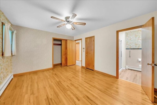 12 Sunset Dr, Afton, NY 13730 - unfurnished bedroom featuring a baseboard radiator, light wood-type flooring, ensuite bathroom, and ceiling fan