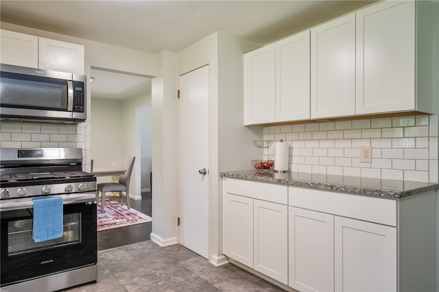 34 Stonewall Ct, Greece, NY 14615 - kitchen with stainless steel appliances, dark stone countertops, white cabinets, and decorative backsplash