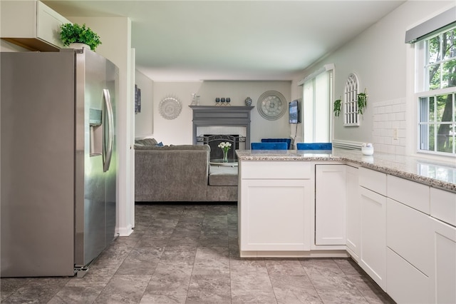 34 Stonewall Ct, Greece, NY 14615 - kitchen with stainless steel fridge, open floor plan, white cabinetry, light stone countertops, and a fireplace