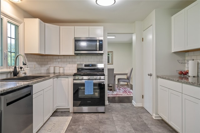 34 Stonewall Ct, Greece, NY 14615 - kitchen featuring appliances with stainless steel finishes, white cabinetry, tasteful backsplash, and light stone counters