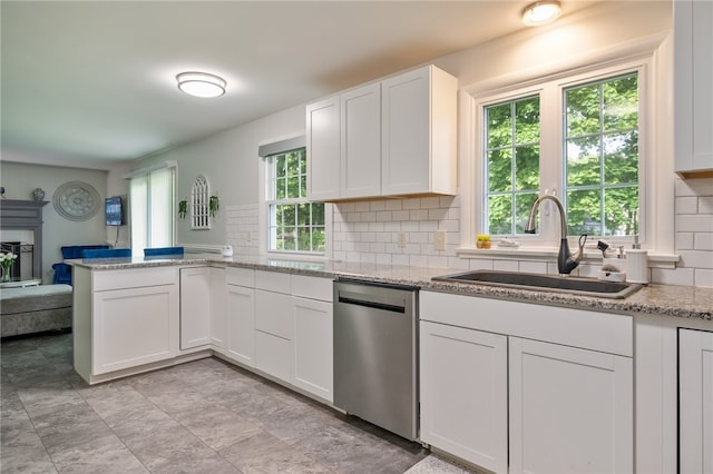 34 Stonewall Ct, Greece, NY 14615 - kitchen featuring stainless steel dishwasher, a peninsula, white cabinetry, backsplash, and light stone counters