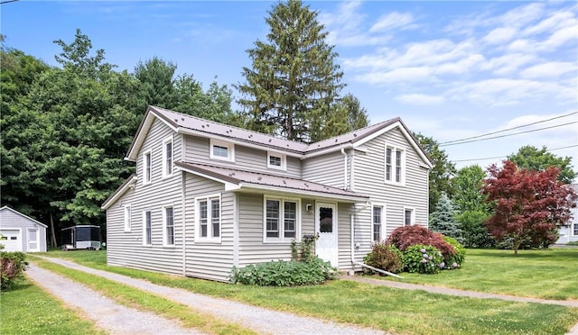 11 Walnut St, Phelps, NY 14533 - traditional-style house featuring a front lawn, a metal roof, driveway, and an outbuilding