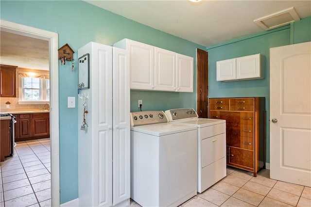 11 Walnut St, Phelps, NY 14533 - laundry room with light tile patterned floors, attic access, washing machine and dryer, and cabinet space