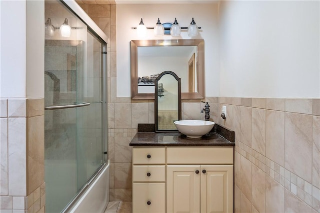 11 Walnut St, Phelps, NY 14533 - bathroom featuring tile walls, vanity, enclosed tub / shower combo, and a wainscoted wall