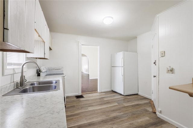 900-902 S Plymouth Ave, Rochester, NY 14608 - kitchen featuring freestanding refrigerator, range, arched walkways, light wood-type flooring, and light countertops