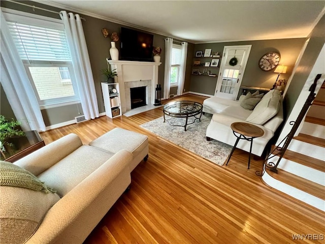 858 Starin Ave, Tonawanda, NY 14223 - living room with a tile fireplace, ornamental molding, wood finished floors, and stairs