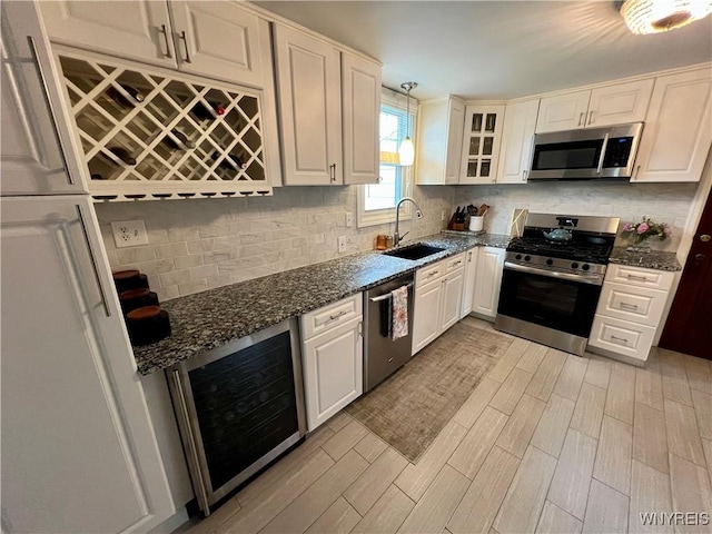 858 Starin Ave, Tonawanda, NY 14223 - kitchen with stainless steel appliances, beverage cooler, light wood-type flooring, tasteful backsplash, and dark stone countertops