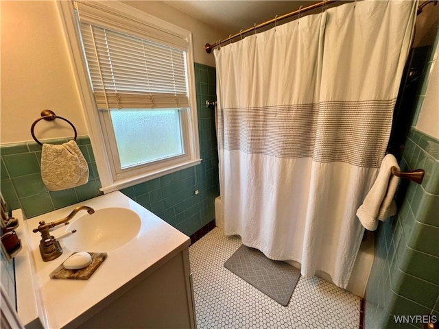 858 Starin Ave, Tonawanda, NY 14223 - bathroom with tile walls, a shower with curtain, vanity, a wainscoted wall, and tile patterned floors