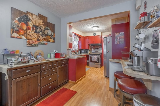 917 W Gray St, Elmira, NY 14905 - kitchen with appliances with stainless steel finishes, a textured ceiling, light wood-type flooring, and light countertops