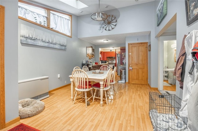 917 W Gray St, Elmira, NY 14905 - dining area featuring light wood-type flooring, a towering ceiling, and a skylight