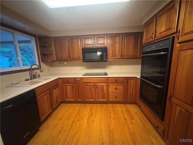 124 N Way, Camillus, NY 13031 - kitchen with black appliances, brown cabinetry, light wood-style floors, and light countertops