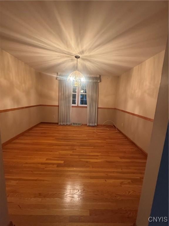 124 N Way, Camillus, NY 13031 - spare room with a chandelier and wood finished floors