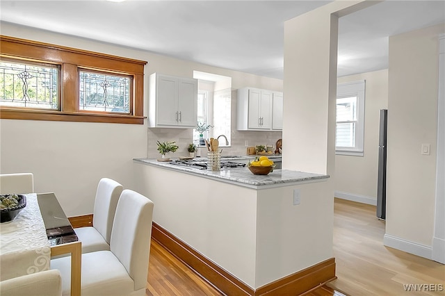 111 Montrose Ave, Buffalo, NY 14214 - kitchen featuring stainless steel appliances, backsplash, light wood-type flooring, and plenty of natural light